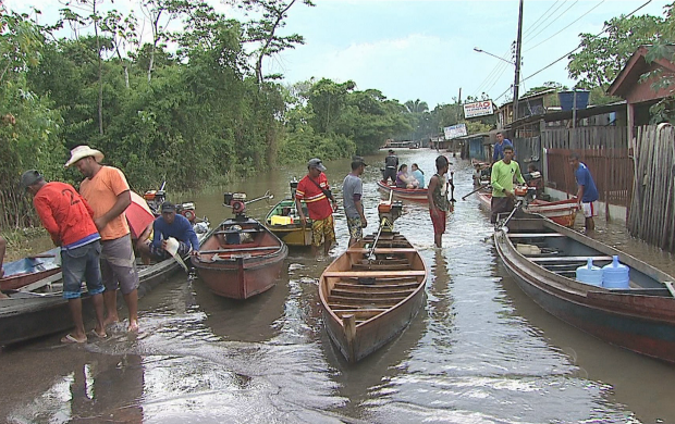 'Catraieiros' conduzem passageiros pelas ruas alagadas de Rio Branco (Foto: Reprodução TV Acre)