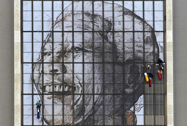 Operários preparam mural em homenagem a Nelson Mandela, neste sábado (15), no prédio do Centro Cívico, na Cidade do Cabo (Foto: AFP)
