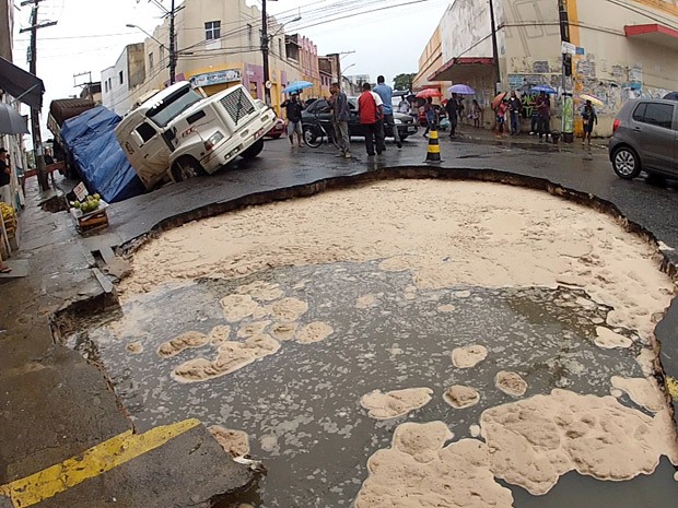 Asfalto cede em frente a carreta, que corre risco de afundar completamente (Foto: Imagens/ Tv Bahia)