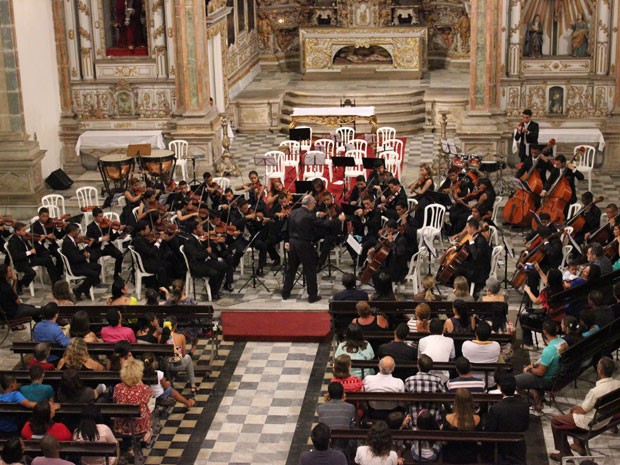 Gustavo Paco rege a Orquestra Criança Cidadã no concerto de aniversário de seis anos, na Igreja da Madre de Deus (Foto: Milton Raulino/ Orquestra Cidadã)