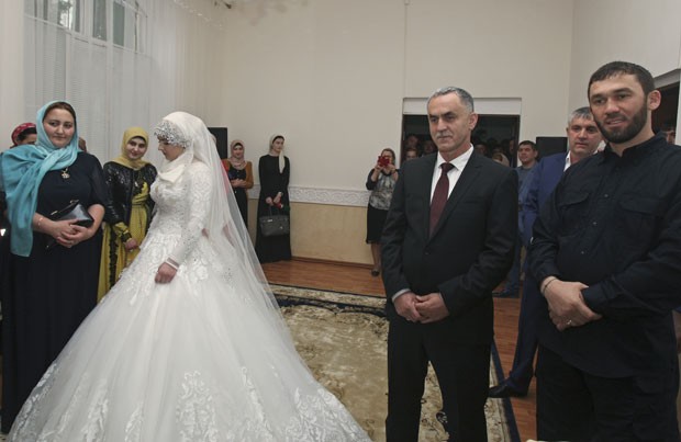 A noiva de 17 anos e seu marido, logo à direita, de 46, na repartição em que oficializaram a união, no sábado (Foto: AP)