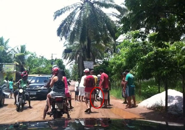 Cobra ficou enrolada no pneu da moto quando motociclista cruzou poça (Foto: Reginaldo Duarte/Divulgação)