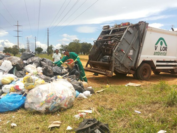 Funcionários que trabalham para a coleta convencional recolhem lixo orgânico deixado pela coleta seletiva (Foto: Aldair Fernando/G1 DF)