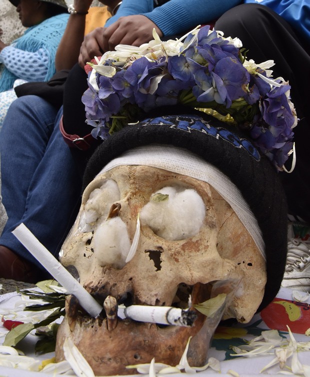  Devotos colocam velas e outras oferendas em frente a crânio humano, em celebração doDia das Ñatitas  (Foto: AFP Photo/Aizar Raldes)