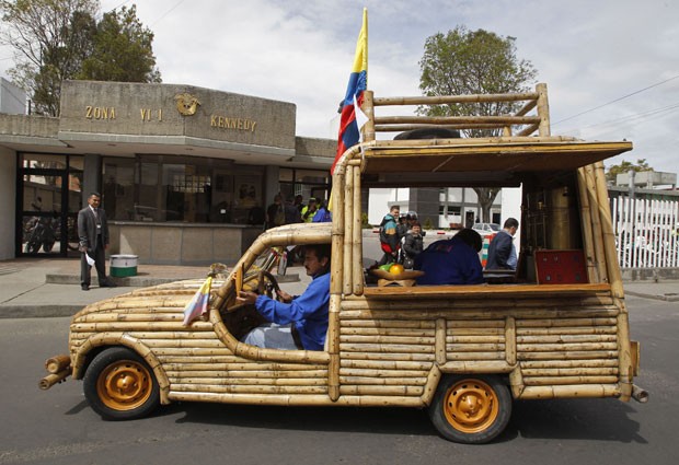  O artista plástico colombiano Jose Mauricio Pardo dirige seu veículo feio de bambu pelas ruas de Bogotá, na Colômbia, na sexta-feira (28).  O automóvel, praticamente todo feito de bambu, foi desenvolvido por Pardo, que montou o “casco” mantendo a mecânica original do veículo. (Foto: AP)