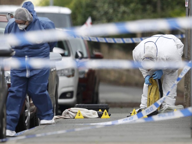 Equipe forense colhe provas na calçada onde ficaram sapatos femininos e uma bolsa após a parlamentar britânica Jo Cox, do Partido Trabalhista, ser morta a tiros em um ataque em Birstall na Inglaterra. As circunstâncias não foram inicialmente esclarecidas (Foto: Phil Noble/Reuters)