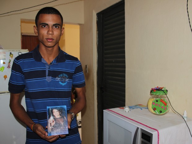 Ítalo, filho único da vítima, exibe foto da mãe (Foto: Gustavo Almeida/G1)