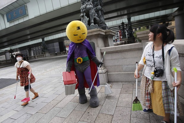 'Lua Cheia' prefere carregar uma vassoura e pá enquanto lidera voluntários na limpeza de áreas na capital japonesa (Foto: Issei Kato/Reuters)