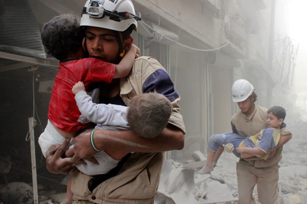 Membros da Defesa Civil resgatam crianças após ataque aéreo na cidade síria de Aleppo (Foto: Sultan Kitaz/Reuters)