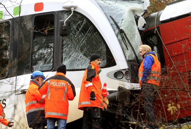 Policiais observam trens de passageiros que se chocaram na manhã desta quinta-feira (10) na Suíça (Foto: Reuters)