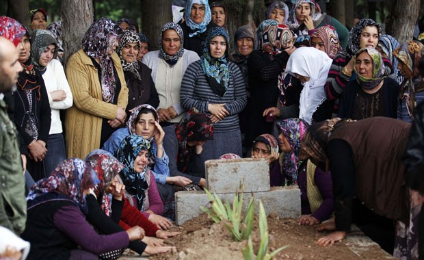 Parentes de Ahmet Uyan, 45 anos, e de Ahmet Ceyhan, 23, mortos nos ataques com carros-bomba neste sábado, participam de funeral após as mortes (Foto: Umit Bektas/Reuters)