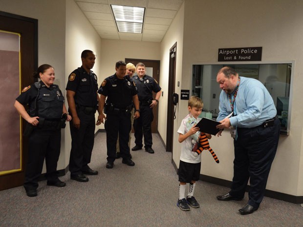 Foto mostra o garoto recebendo de volta seu tigre de pelúcia, Hobbes (Foto: Reprodução/Facebook/Tampa Internacional Airport)