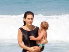 Com maiô comportado, Claudia Abreu curte praia com a família