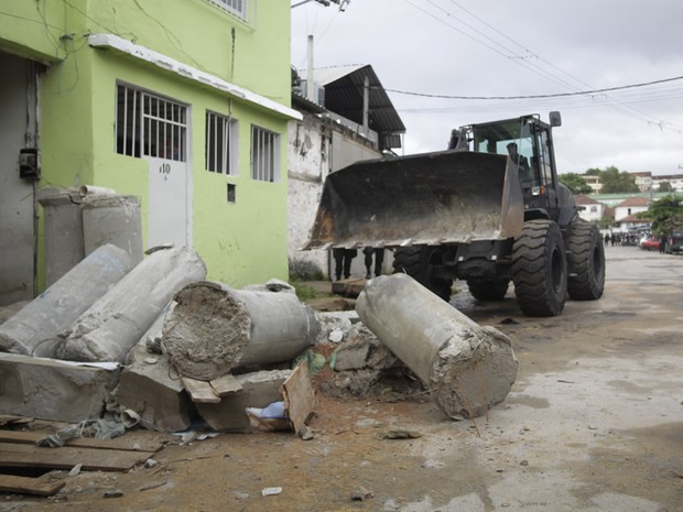 Retroescavadeira retira manilhas de rua na comunidade de Manguinhos (Foto: Ide Gomes/G1)