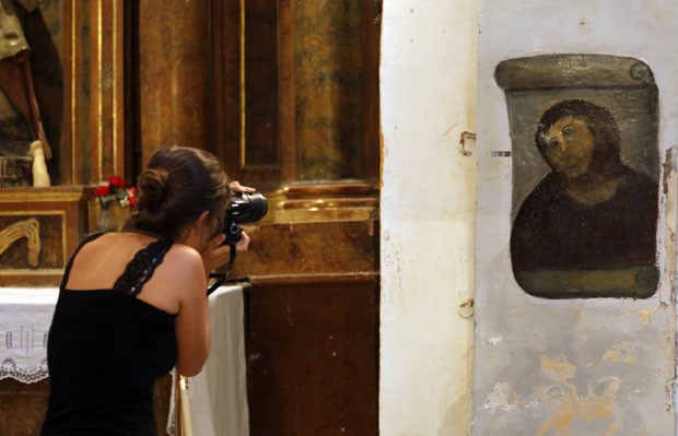 Turista fotografa obra restaurada por Cecilia Giménez em igreja na Espanha. (Foto: Censar Manso/AFP)