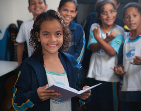 LEITURA Com os cabelos molhados da aula de surfe, Ingrid do Rosário, de 8 anos,  faz reforço  de português no  Projeto Ondas   (Foto: Guilherme Zauith/ÉPOCA)