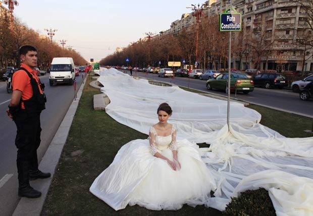 No dia 20 de março, um vestido de noiva com uma cauda de 2.750 metros foi exibido em Bucareste, na Romênia. A antiga marca era de 2.488 metros. Foram utilizados 4.700 metros de material e 1.857 agulhas. O vestido exibido pela modelo Emma levou 100 dias para ficar pronto. (Foto: Radu Sigheti/Reuters) No dia 20 de março, um vestido de noiva com uma cauda de 2.750 metros foi exibido em Bucareste, na Romênia. A antiga marca era de 2.488 metros. Foram utilizados 4.700 metros de material e 1.857 agulhas. O vestido exibido pela modelo Emma levou 100 dias para ficar pronto. (Foto: Radu Sigheti/Reuters)