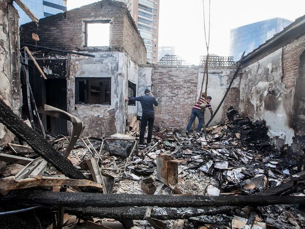 Homens são vistos no escritório da contadora Meire Poza, em São Paulo, que trabalhou para o doleiro Alberto Youssef, delator da Operação Lava Jato. O local foi atingido por um incêndio durante a madrugada e ficou completamente destruído (Foto: Mario Ângelo/Sigmapress/Estadão Conteúdo)