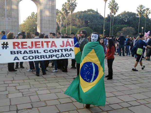 Manifestante usa máscara e veste a bandeira do Brasil durante protesto em Porto Alegre (Foto: Diego Guichard-G1)