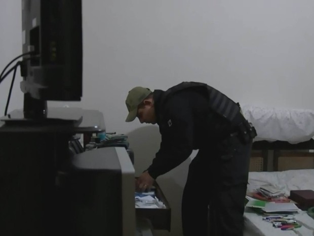 Policial procura por material em casa de suspeito na região de Araçatuba (Foto: Reprodução / TV TEM)