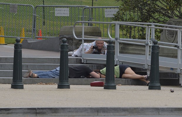 Pessoas se protegem após tiroteio perto do Capitólio (Foto: Jewel Samad/AFP)