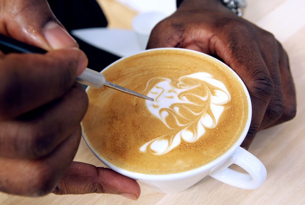 Artista desenha formas e figuras em xícaras com café com leite (Foto: Jean Christophe/AFP)