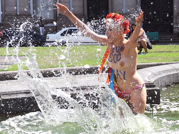 Representantes do movimento feminista protesta dentro de um lago artificial em frente à Igreja da Candelária (Foto: Vanderlei Almeida / AFP)