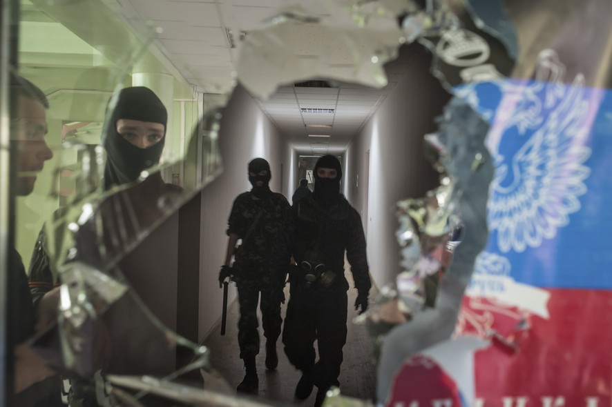 Militantes mascarados pró-Rússia patrulham prédio da administração local em Mariupol, na Ucrânia. Um líder do movimento disse que observadores militares estrangeiros (suspeitos de serem espiões da OTAN) podem ser libertados em troca da liberação de ativis