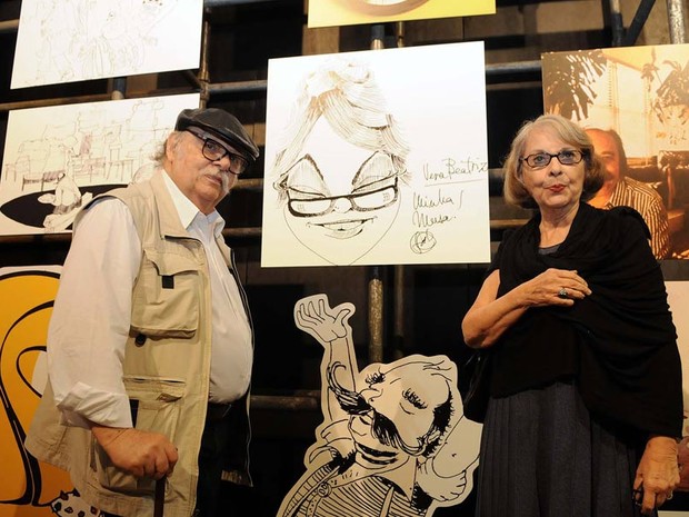 Sérgio Rodrigues e a mulher, Vera Beatriz, ao lado da caricatura em que o designer homenageia a "musa" (Foto: Alexandre Durão / G1)