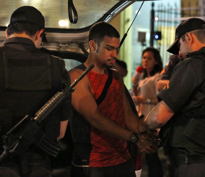 O rapaz é algemado antes de ser conduzido para a delegacia (Foto: Ellen Soares/Gshow)