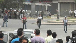 Milicianos da Shabiha intimidam participantes do funeral de um opositor do regime em Damasco (Foto: AP)