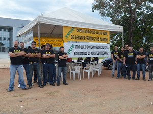 Os agentes penduraram as algemas em sinal de protesto à desvalorização da carreira (Foto: Emily Costa/G1)