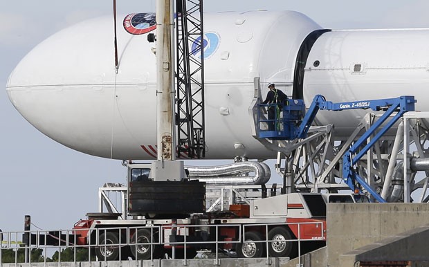 Funcionários da SpaceX trabalham na manutenção do foguete Falcon 9, que deve ser lançado ao espaço nesta terça-feira (10) (Foto: John Raoux/AP)
