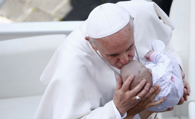 Francisco beija bebê ao final de sua missa de canonização, neste domingo (12), no Vaticano (Foto: Tony Gentile/Reuters)