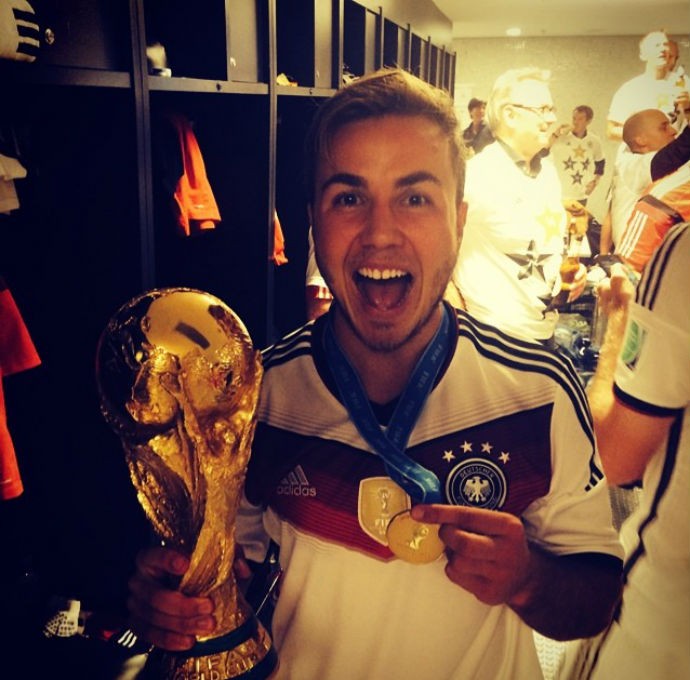 Götze posa com a taça de campeão do mundo e sorri muito no vestiário (Foto: Reprodução/Twitter)