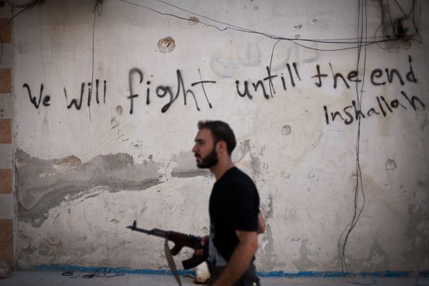 Soldado rebelde patrulha rua da cidade síria de Aleppo nesta terça-feira (11) (Foto: AFP)