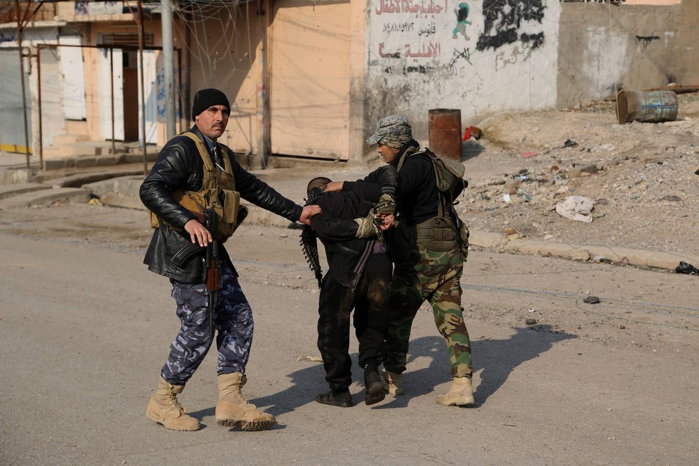Forças iraquianas detêm suspeito pertencer ao Estado Islâmico, na quarta-feira (4), em Mossul (Foto: Khalid Mohammed/AP)