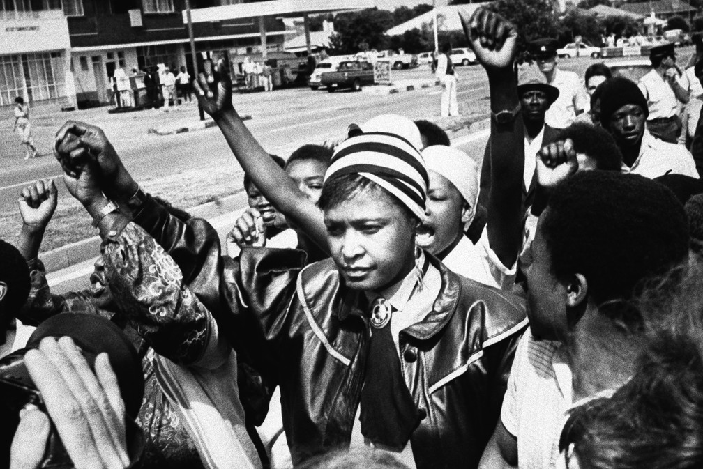 Em imagem de janeiro de 1986, a ativista Winnie Mandela recebe o apoio apÃ³s comparecer a corte a oeste de Johanesburgo em audiÃªncia sobre sua prisÃ£o por desrespeitar ordem quea proibe de morar em sua casa em Soweto (Foto: AP Photo, File)