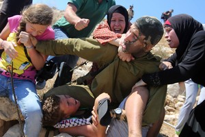 Menina palestina morde soldado israelense que imobilizou criança (Abbas Momani/AFP)