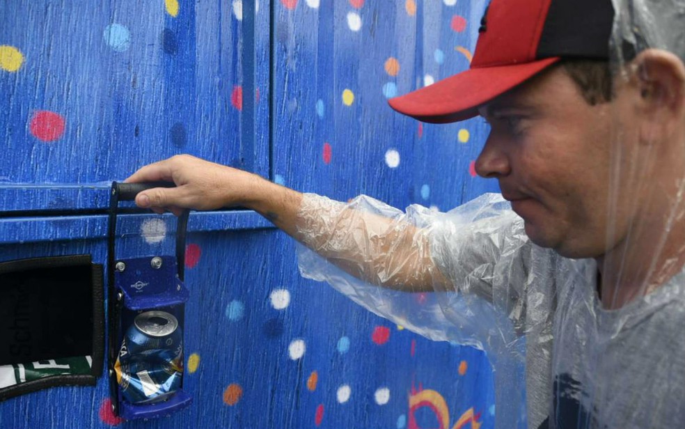 Folião usa amassador de lata em container de coleta no carnaval de rua de Brasília (Foto: Adriano Machado/Divulgação BOA)