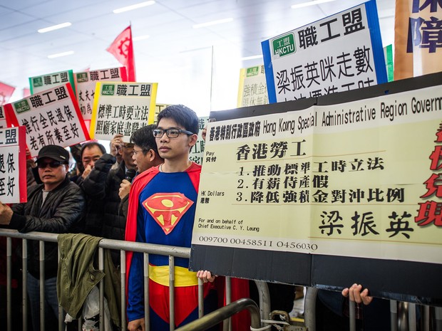 Manifestantes exibem cartazes contra o presidente-executivo Leung Chun-ying antes de seu discurso político em Hong Kong. (Foto: Philippe Lopez/AFP)