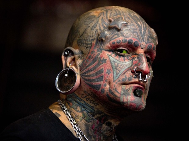 Victor Peralta exibe seu rosto tatuado na feira (Foto: Natacha Pisarenko/AP)