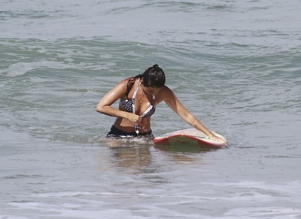 Dani confere se o biquíni está no lugar certo antes de sair do mar (Foto: AG News)