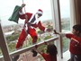 Em comemoração à chegada do Natal, funcionário de um hotel de Surabaya, na Indonésia, limpa as janelas do prédio vestido de Papai Noel - e faz a alegria da criançada
