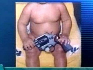 Foto de bebê com arma no colo foi apreendida pela polícia (Foto: Polícia Civil/Divulgação)