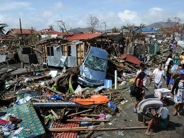 Moradores andam por região devastada por supertufão na cidade de Tacloban (Foto: Ted Aljibe/ AFP)