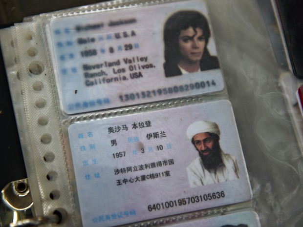 Carteiras de identidade com fotos do terrorista Osama bin Laden e o músico Michael Jackson são vendidos na China (Foto: Greg Baker/AFP)