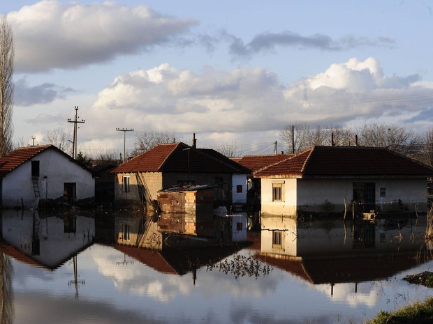 Casas e seus reflexos são vistos em um quintal inundado na Macedônia. Um homem morreu afogado e centenas de casas foram alagadas nesta terça-feira (26) na região (Foto: REUTERS / Ognen Teofilovski)