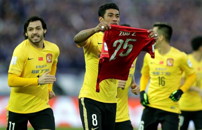 Paulinho comemora seu gol mostrando camisa do zagueiro Zou Zheng, que sofreu fratura no Mundial (Foto: EFE)