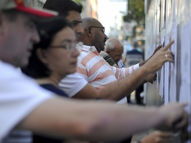 Eleitores checam listas antes de votação em Caracas. Pleito irá definir quem governará o país após a morte de Hugo Chávez (Foto: Juan Barreto/AFP)